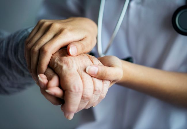 helping nurse holding an elder hand