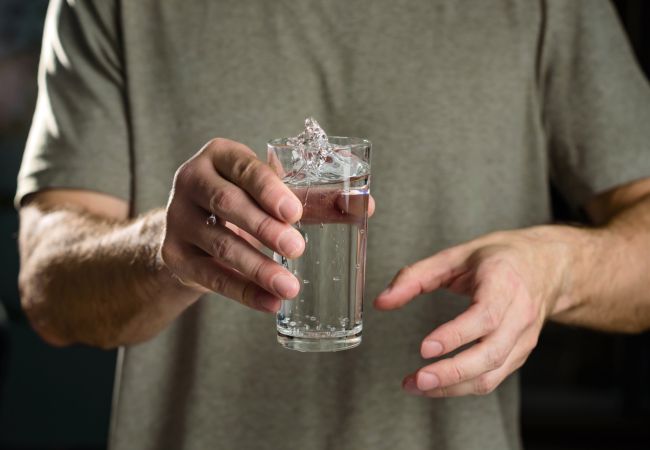 Man holding glass of shaking water